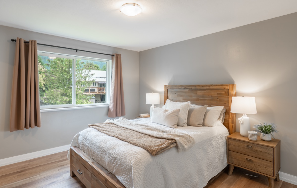 Bedroom with a wood bed frame and a large window