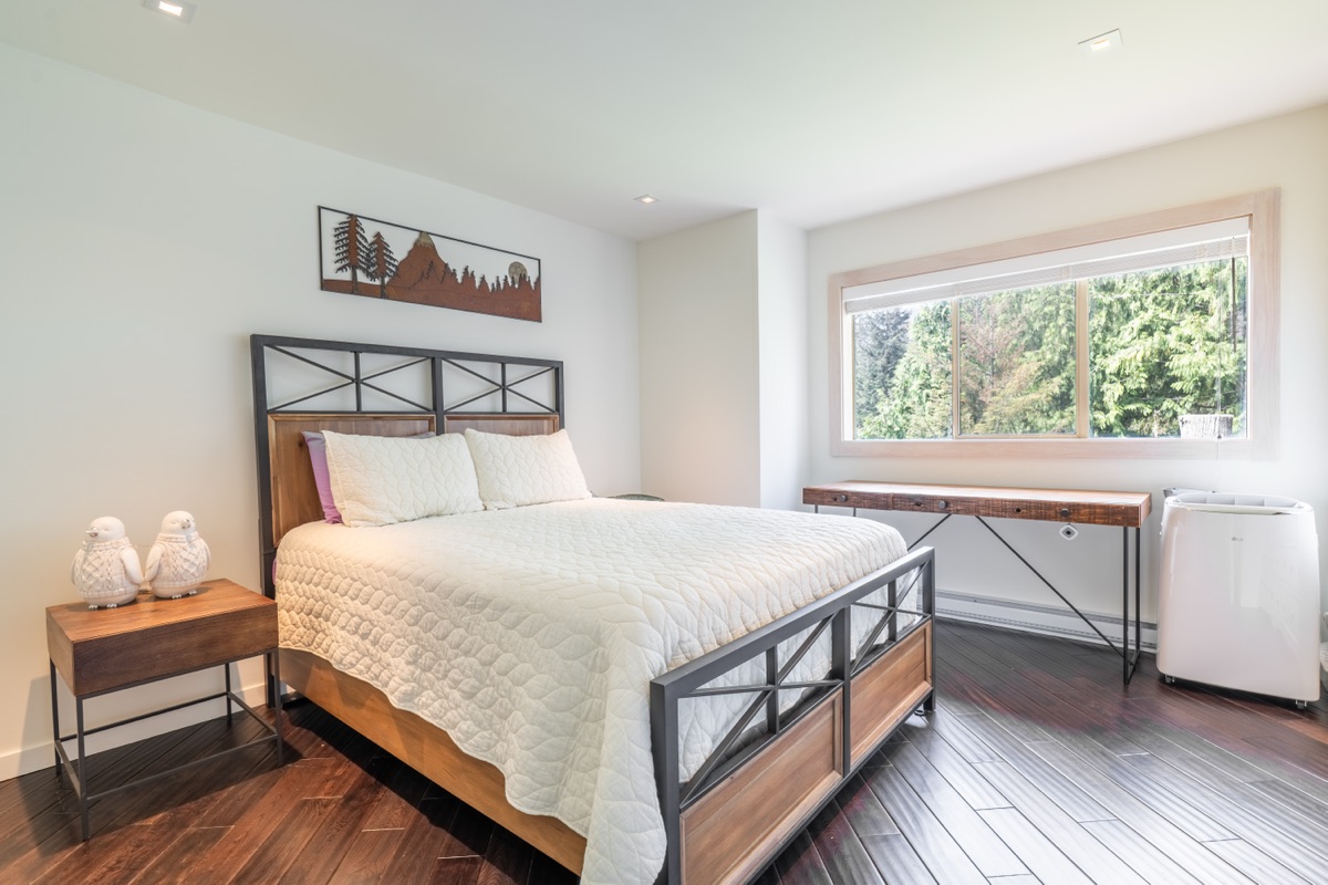 Main bedroom with a metal-frame bed and large window