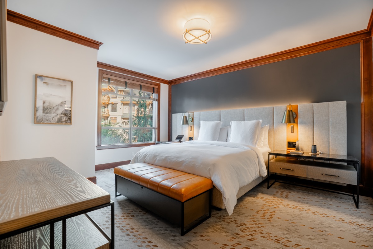 Bedroom with a king bed and orange leather bench