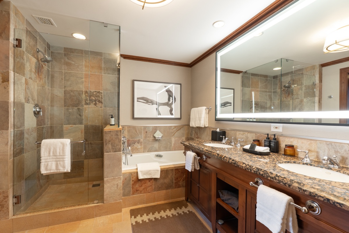Bathroom with a stone-tile shower, soaking tub and double vanity