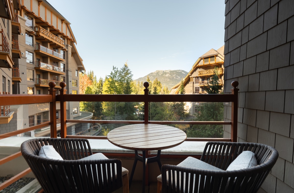 Balcony with a small table, two chairs and a mountain view