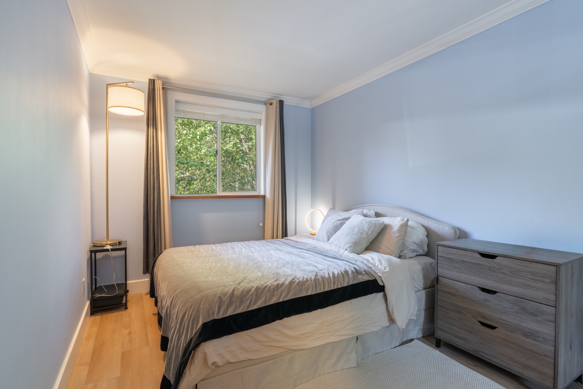 Bedroom with a window and wood dresser