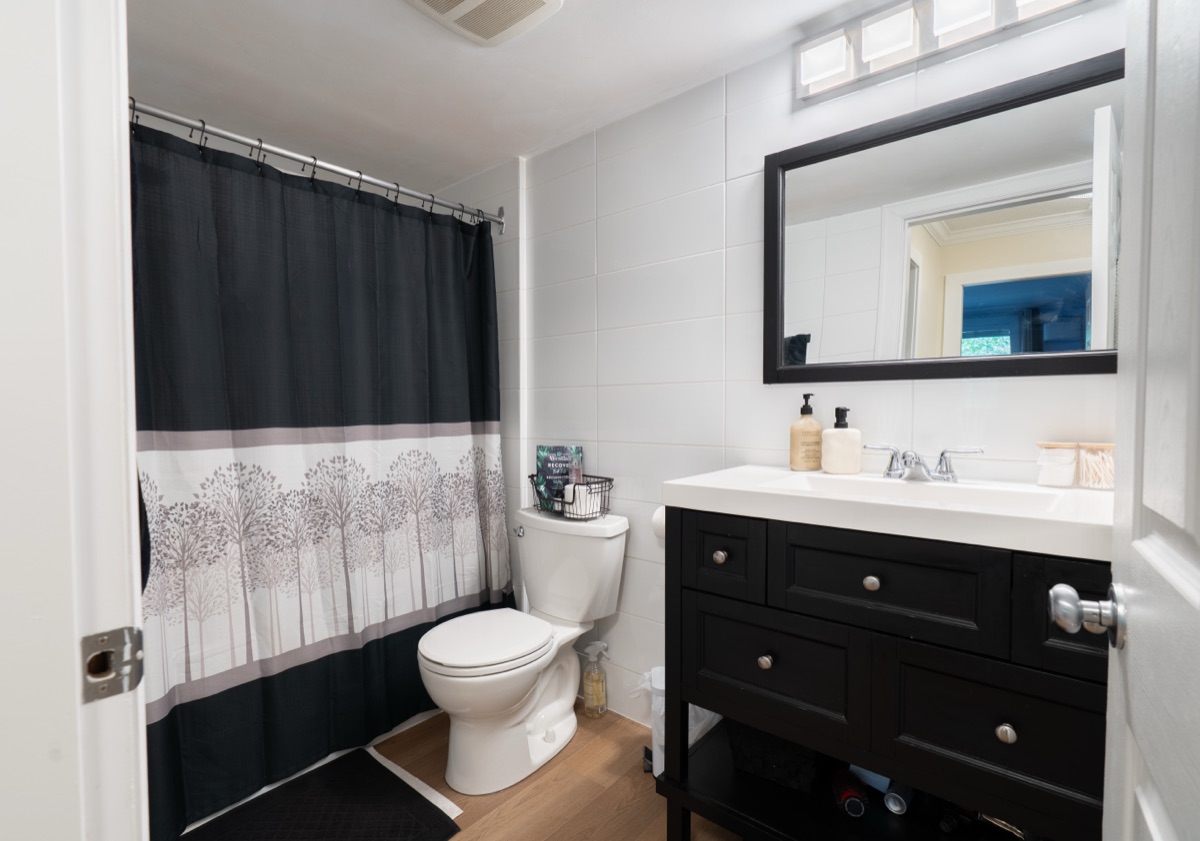 Bathroom with a black vanity and shower curtain